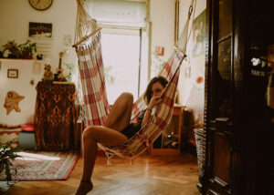 Young woman laying in hammock in apartment