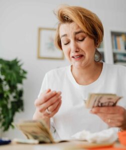 Frustrated woman counting money to pay her car insurance.